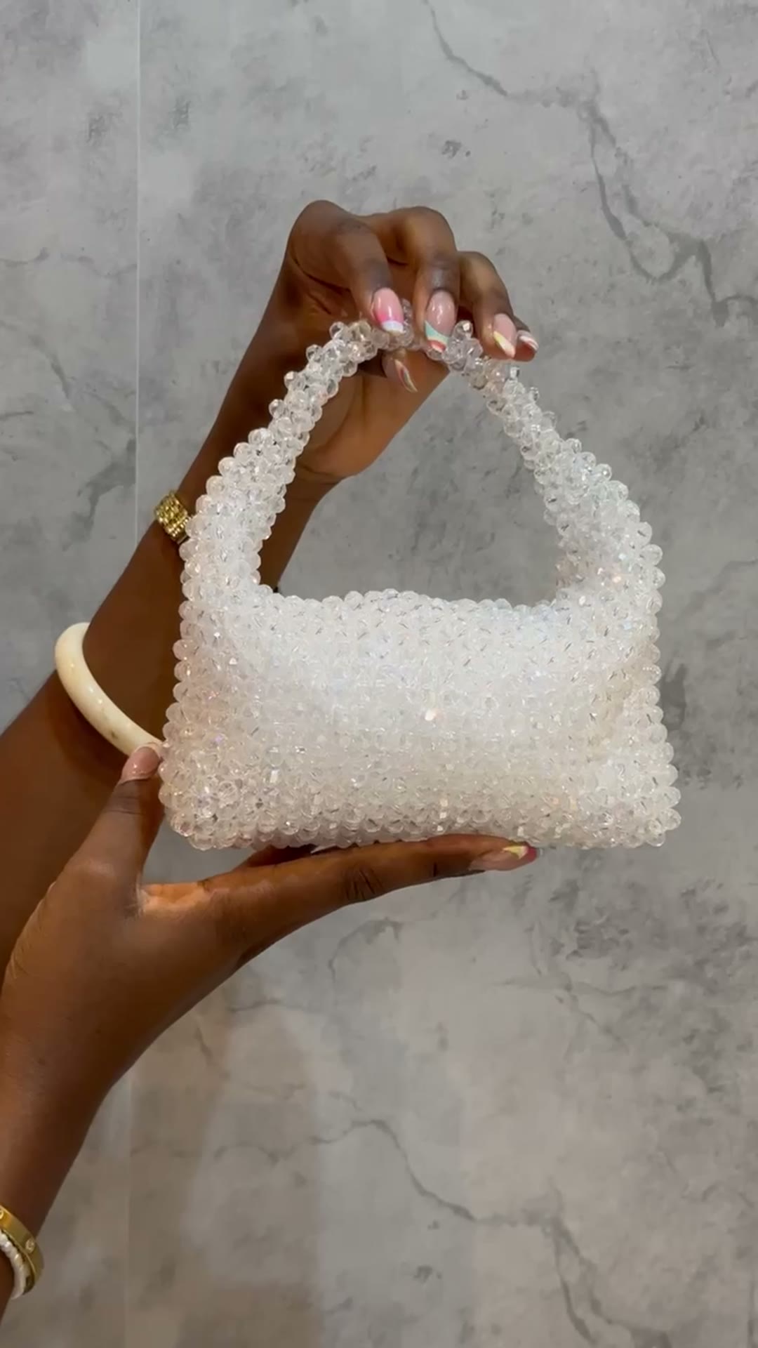 A white crystal-beaded top-handle bag